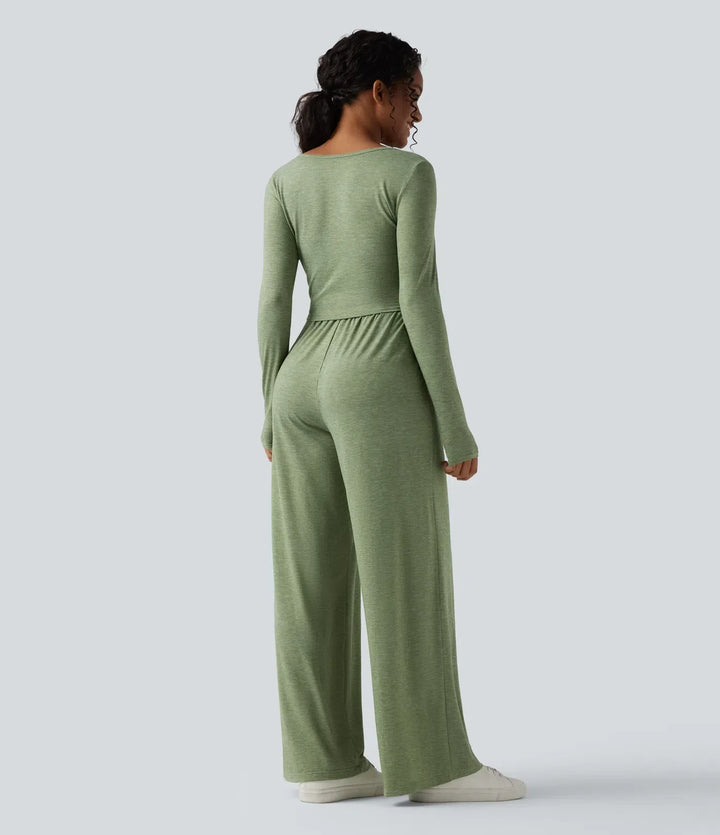 Baksidesvy av grön långärmad jumpsuit för dam med ledig passform