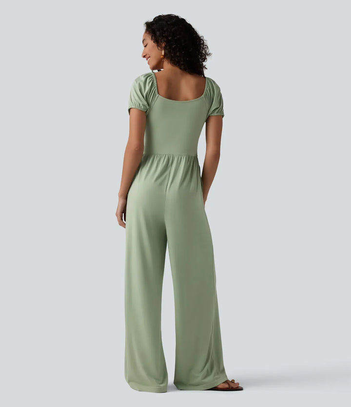 Bakifrån av dam jumpsuit med kort puffärm och långa ben