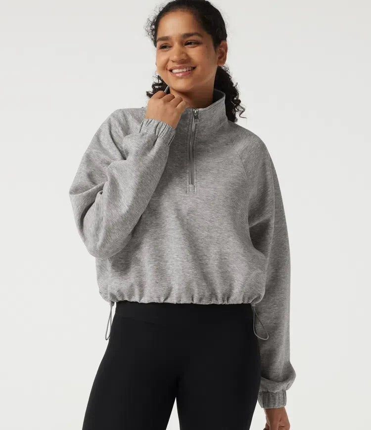 Kvinna i grå sweatshirt med halvdragkedja framifrån
