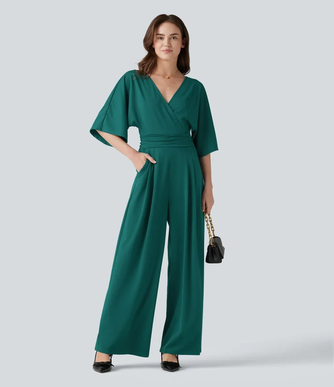 Festlig damjumpsuit i grönt tyg med stilren och elegant design