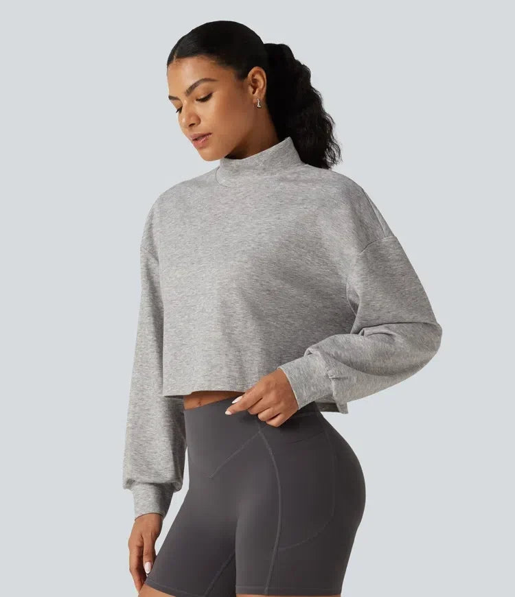 Kvinna som bär grå croppad sweatshirt med halvpolokrage framifrån