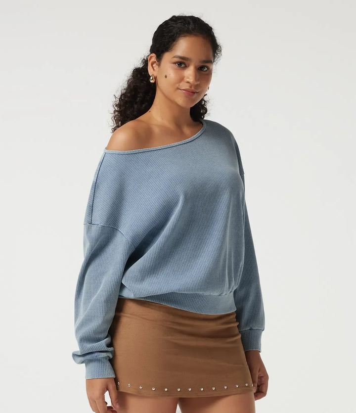 Närbild på modell i blå vardaglig sweatshirt med båtringning