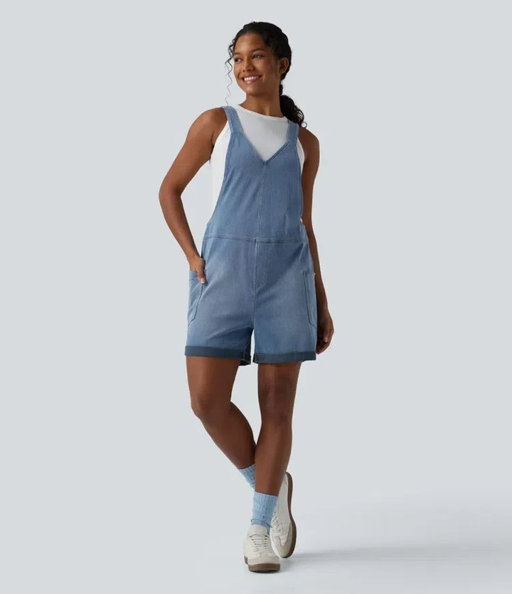 Kort overall i tvättad denim för dam framifrån med vita sneakers