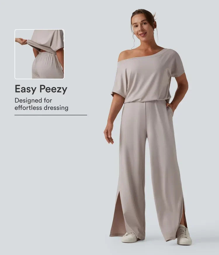 Kvinna i beige enaxlad jumpsuit med slits och fickor framifrån