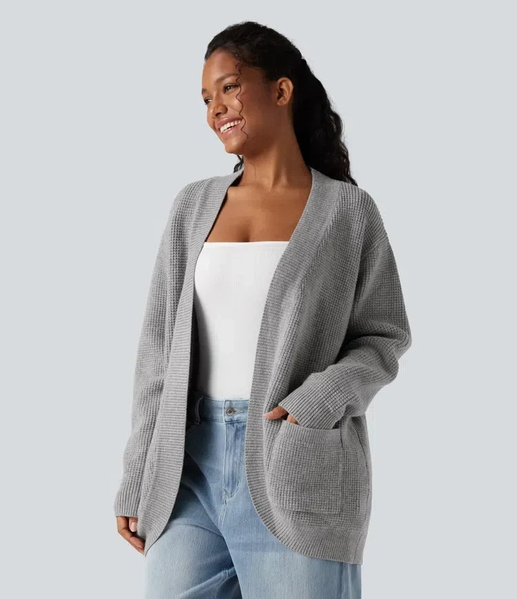 Kvinna som bär grå långärmad cardigan med öppen front och fickor