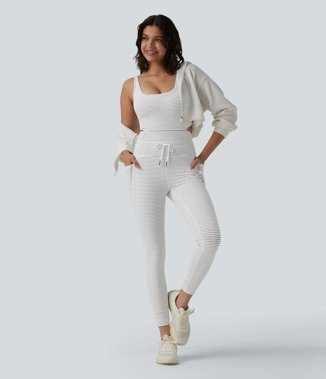 Detaljbild på fickor och dragsko på randig sportjumpsuit för dam