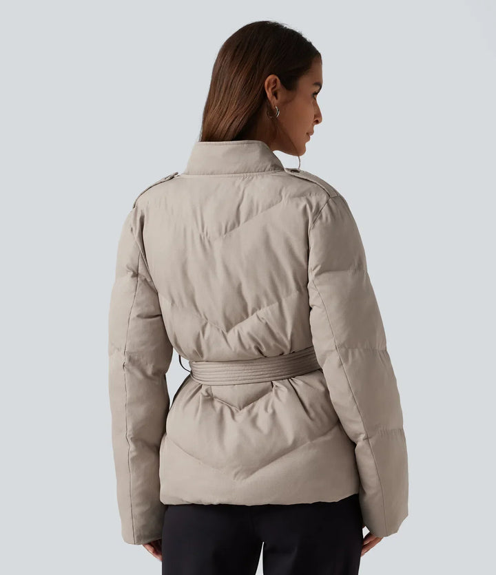 Bakifrån av dam i beige jacka med skärp och krage