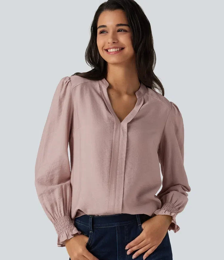 Kvinna i rosa V-ringad blus med lång puffärm framifrån