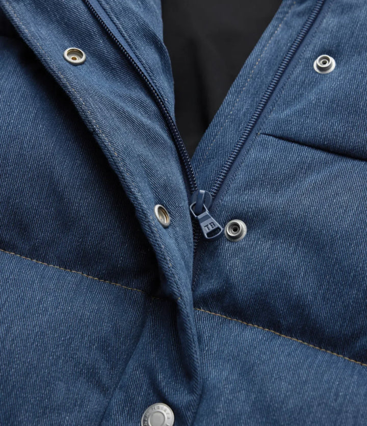 Vadderad damväst i denimblått upphängd på galge för vardagsmode