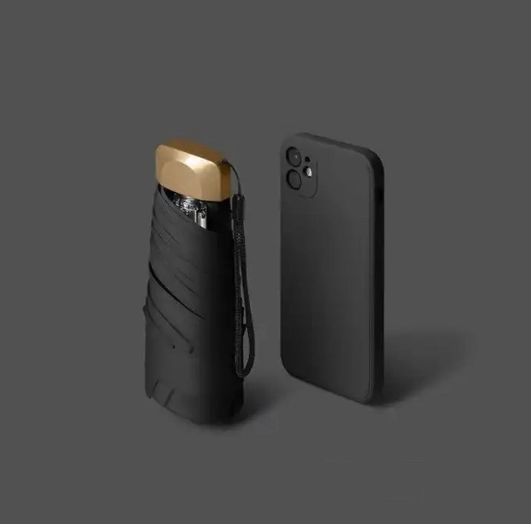 Aurelia kompakt fickparaply i svart bredvid en smartphone