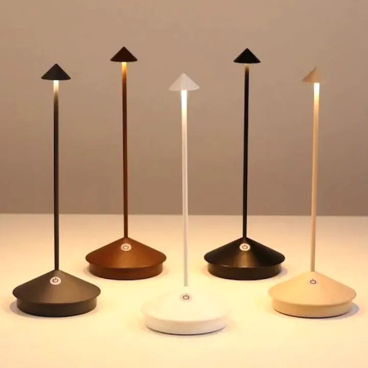 Trådlös LED-lampa tänd i skymningen på ett dukat trädgårdsbord utomhus