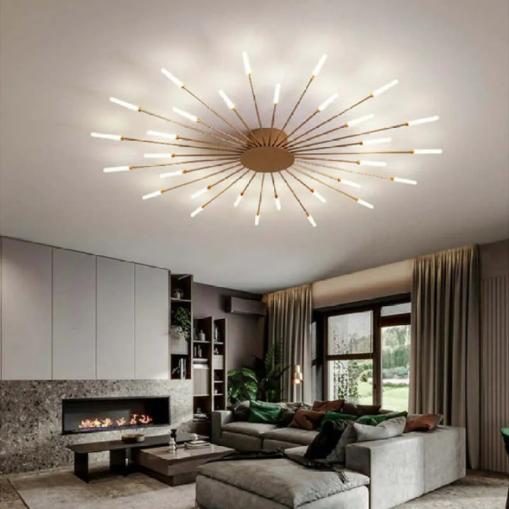 Modern taklampa i guld monterad i ett stilrent vardagsrum med soffgrupp