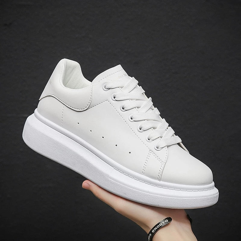 Vita urbana sneakers för dam som hålls upp i handen