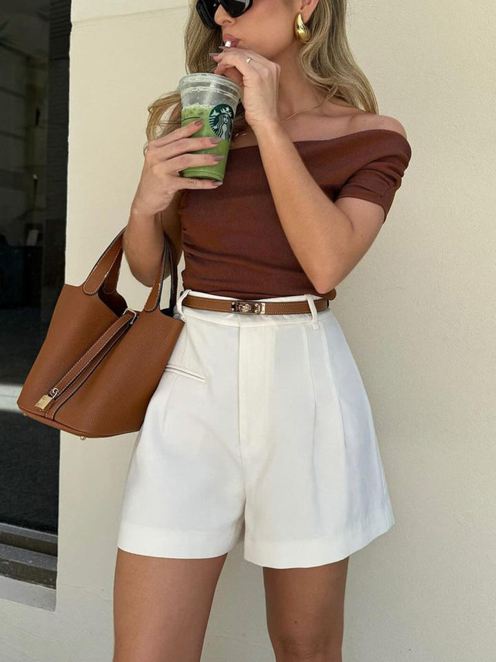Närbild på kvinna som dricker iskaffe iförd vita shorts
