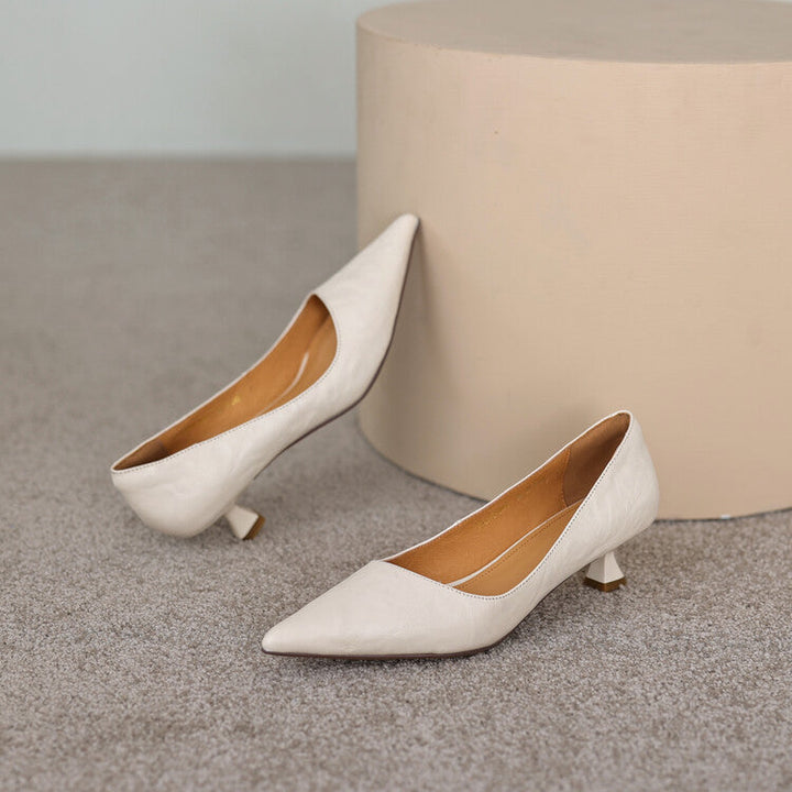 Stilrena svarta pumps med blank finish från vinkeln ovanför