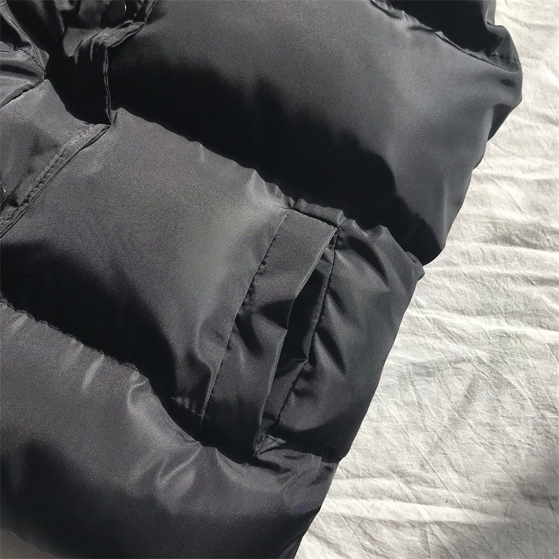 Detaljbild på svart pufferväst dam med hög krage