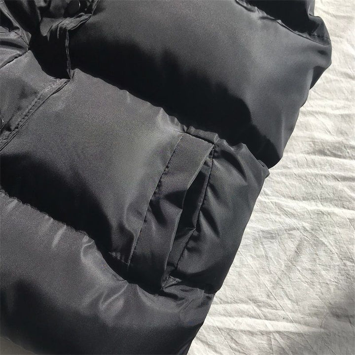 Detaljbild på svart pufferväst dam med hög krage