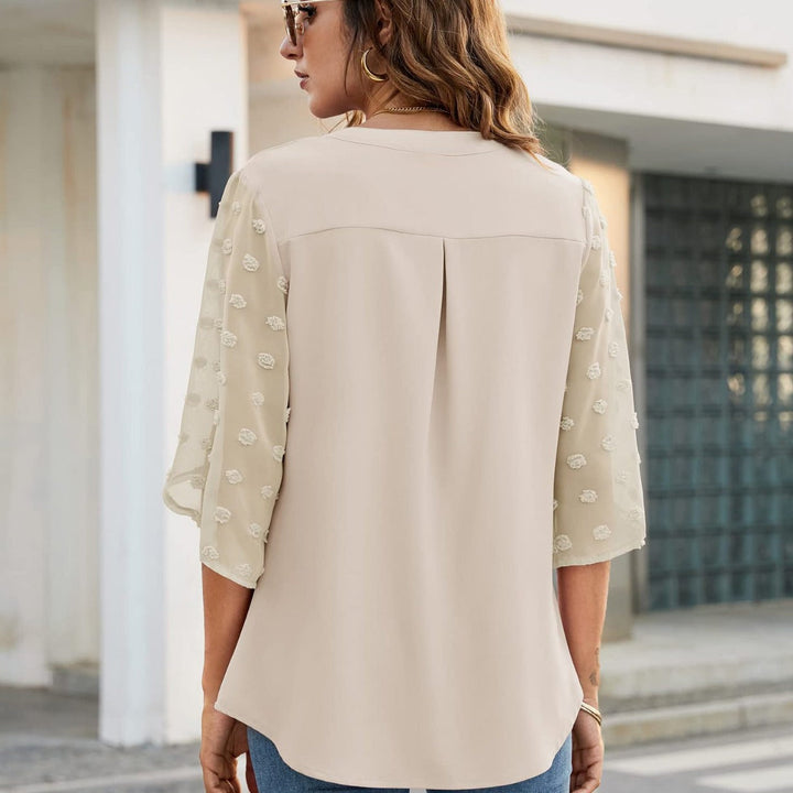 Elegant damtopp med v-ringning och transparenta långa ärmar i stilren design