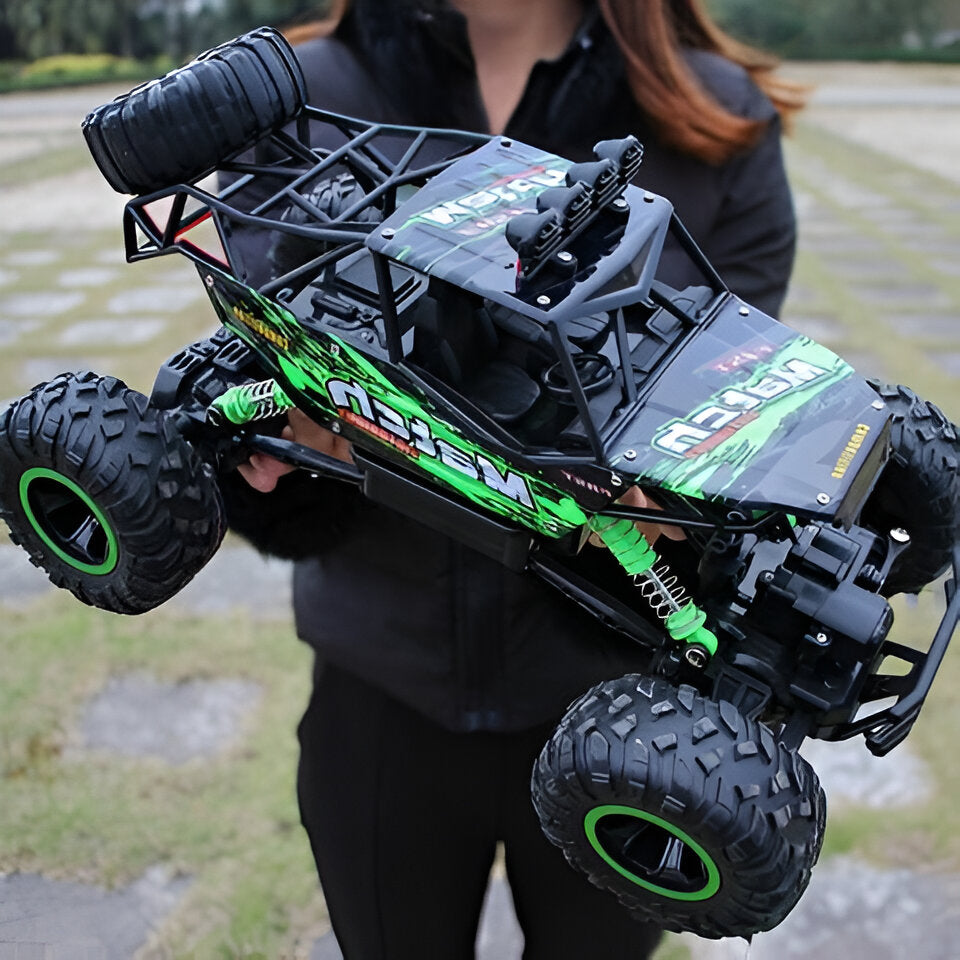 Grön 4x4 radiostyrd monstertruck som hålls upp i terrängen
