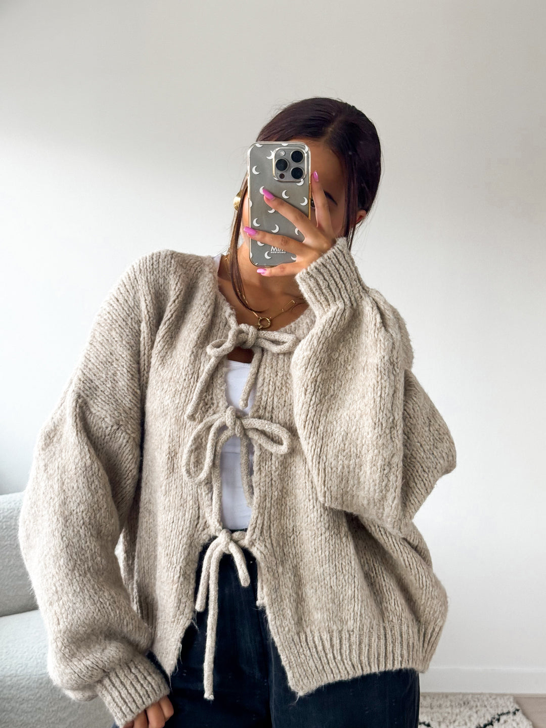 Dam i stickad beige cardigan med knytband framtill