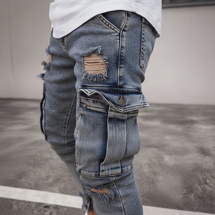 Närbild på cargofickor och slitna designdetaljer på denimbyxor