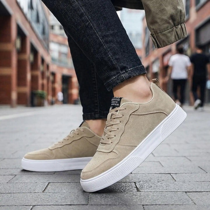 Man i beiga låg-top sneakers utomhus