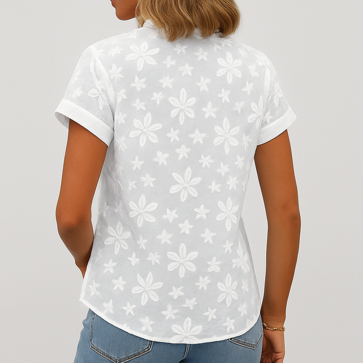 Baksidan av den vita blommiga damblusen med kort ärm