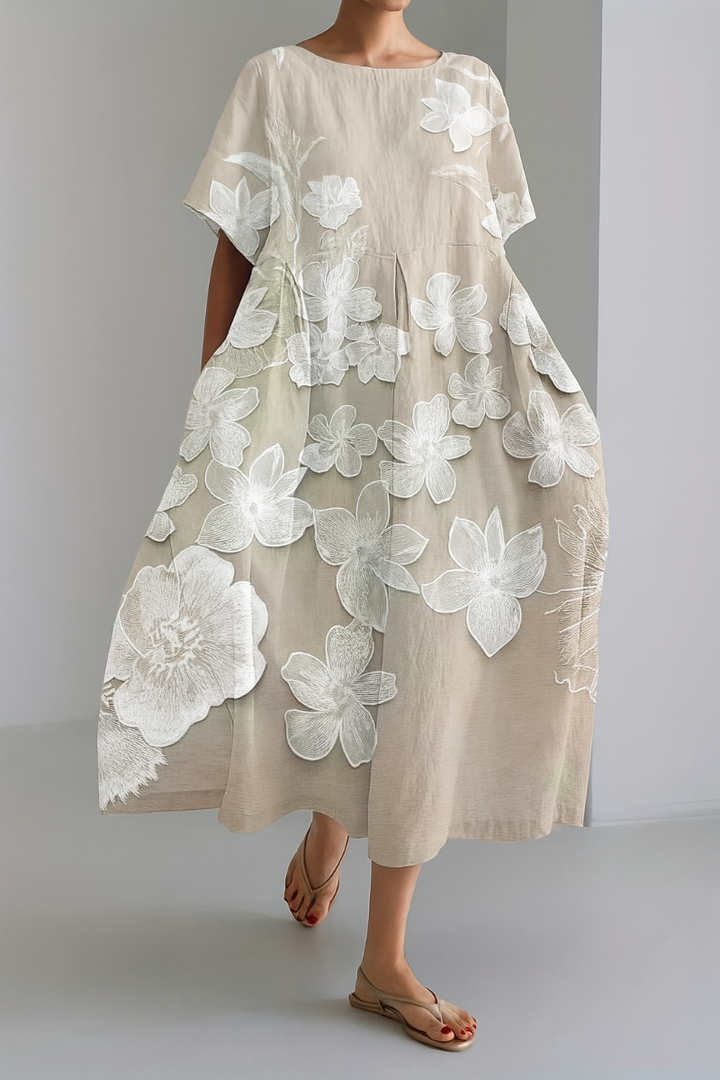 Kvinna som bär en beige maxiklänning med blommönster