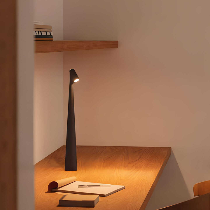 Svart Carvallo dimbar bordslampa placerad på träskrivbord i arbetsrum