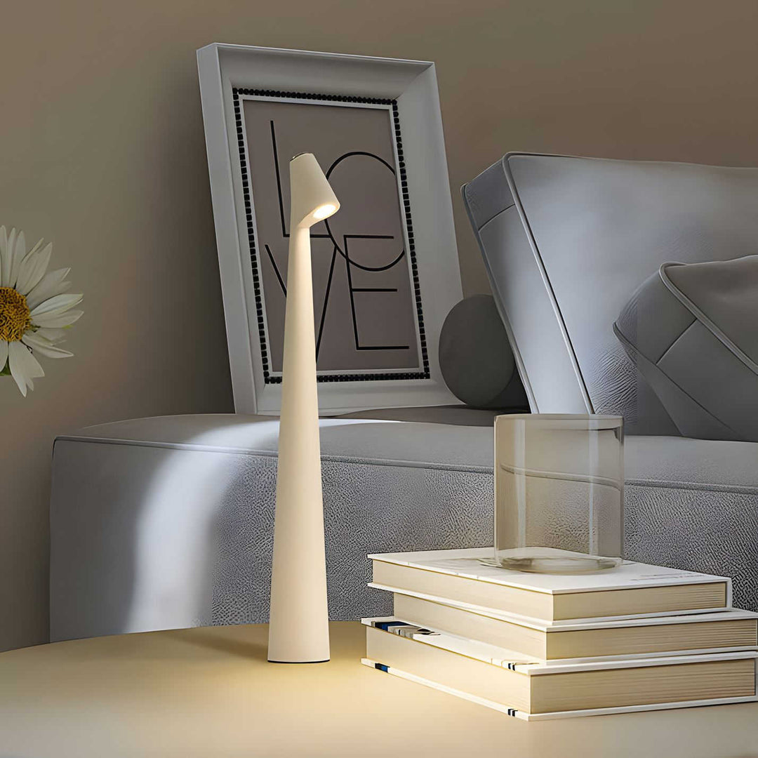 Vit Carvallo elegant bordslampa bredvid böcker och soffa i vardagsrum