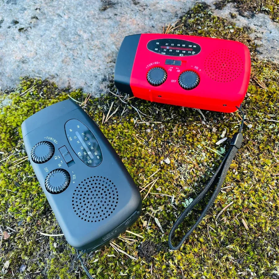 Röd och svart nödradio placerade på mossa i utomhusmiljö
