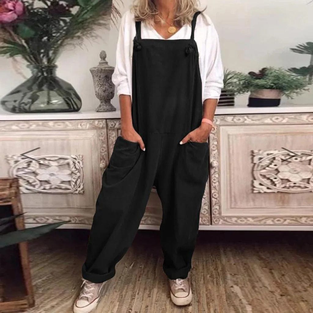 Dam i svart ärmlös jumpsuit med vida ben i rumsmiljö