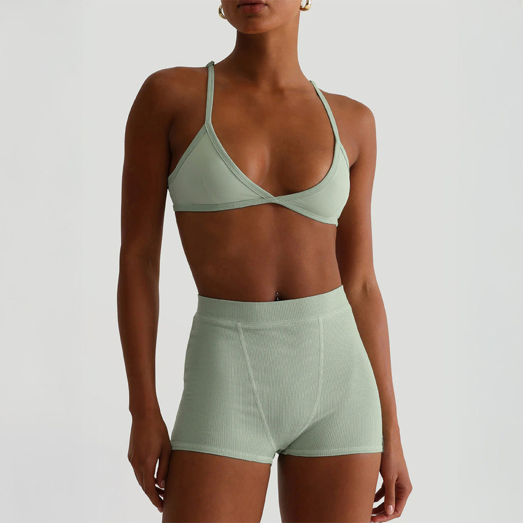 Modell i bohnengrön sport-bh och höga shorts
