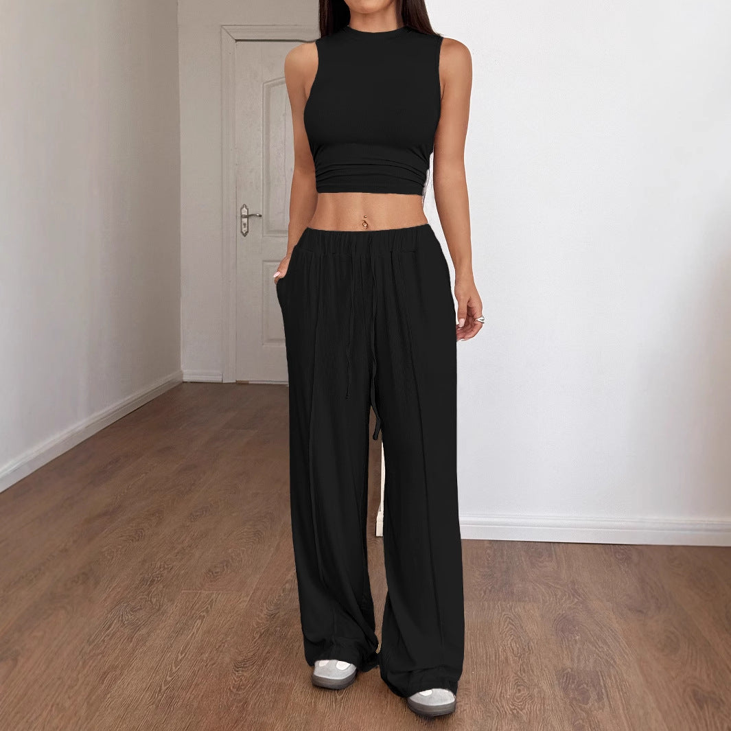 Dammodell i svart tvådelat set med crop top och lösa byxor