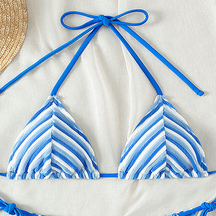 Helfigursbild på dam i blå texturerad badkläder, perfekt stil för sommar och strand.