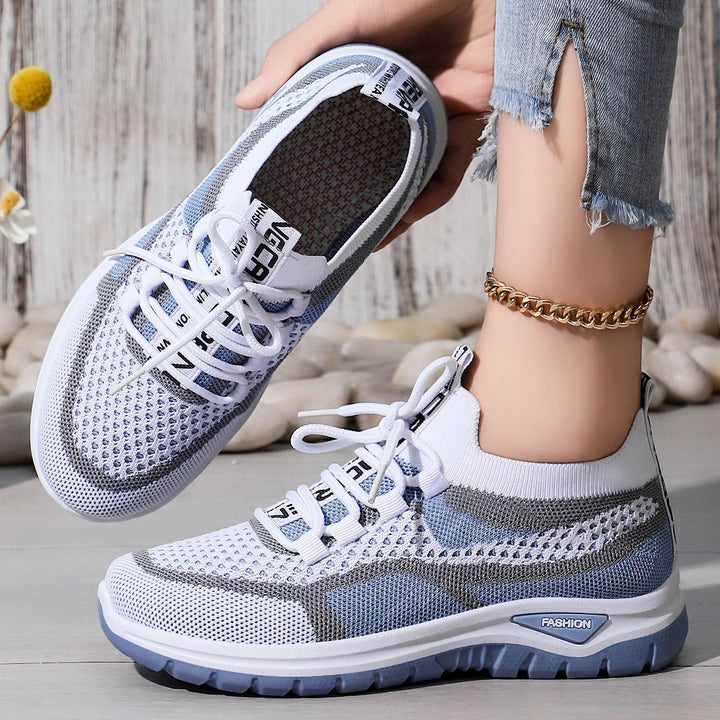Närbild på vita och blå ortopediska sneakers för dam med mönstrad ovandel