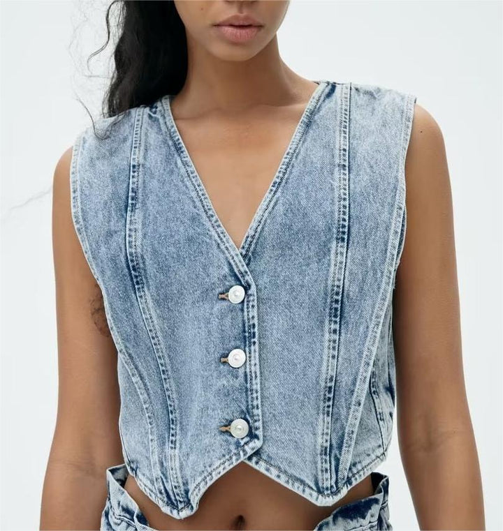 Modell som bär ljusblå cropped denimväst med knappar framtill