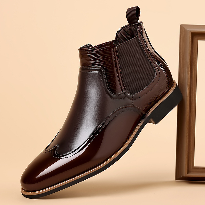 Klassiska chelsea boots i brun färg mot ljus bakgrund