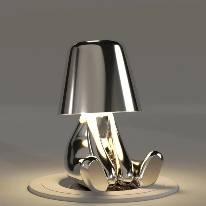 Stilren bordslampa tänd i ett minimalistiskt inrett arbetsrum