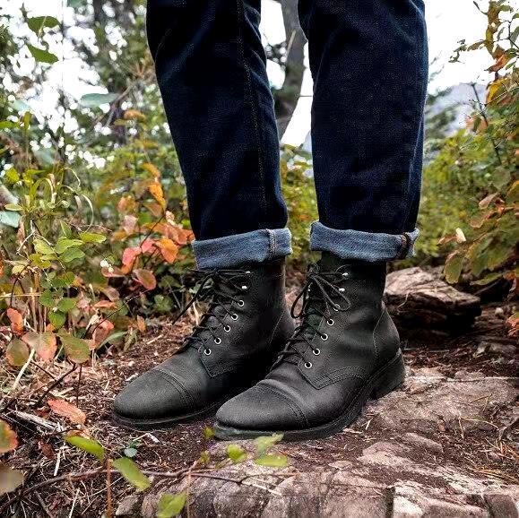 Svarta herrkängor burna med jeans utomhus