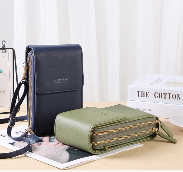 Modell som bär den svarta crossbody-väskan över axeln