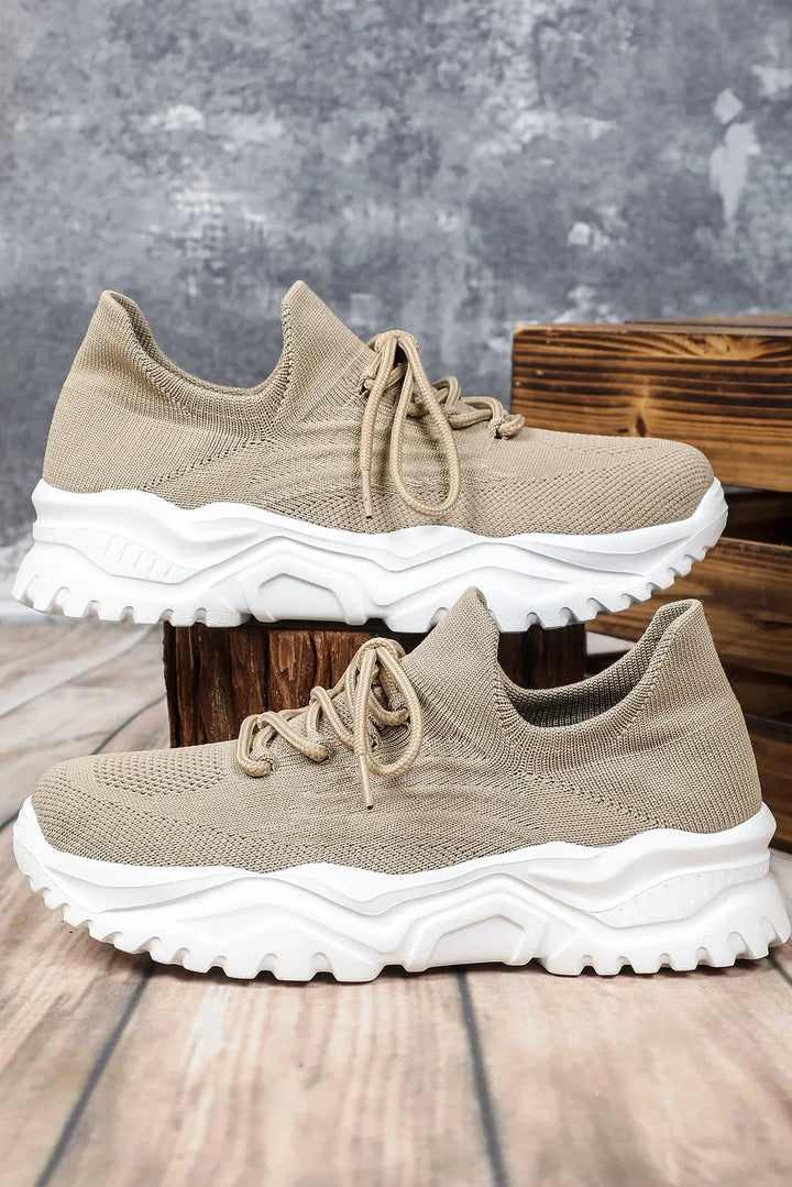 Beige dam sneakers Julika med kraftig vit sula stående på trälåda