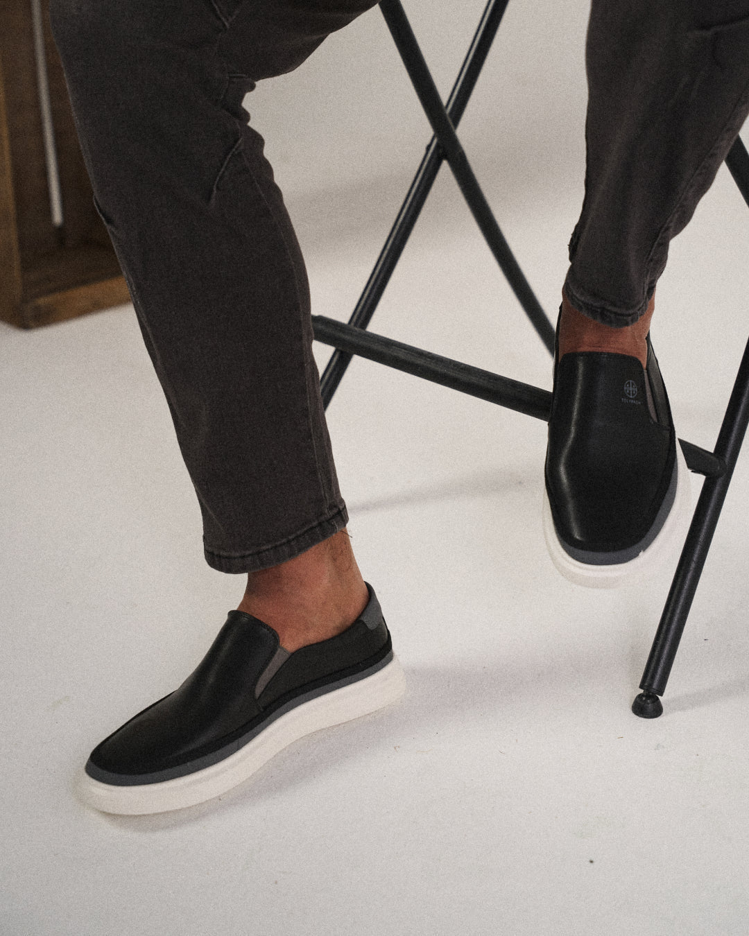 Närbild på ovandelen av svarta slip-on-skor för herrar