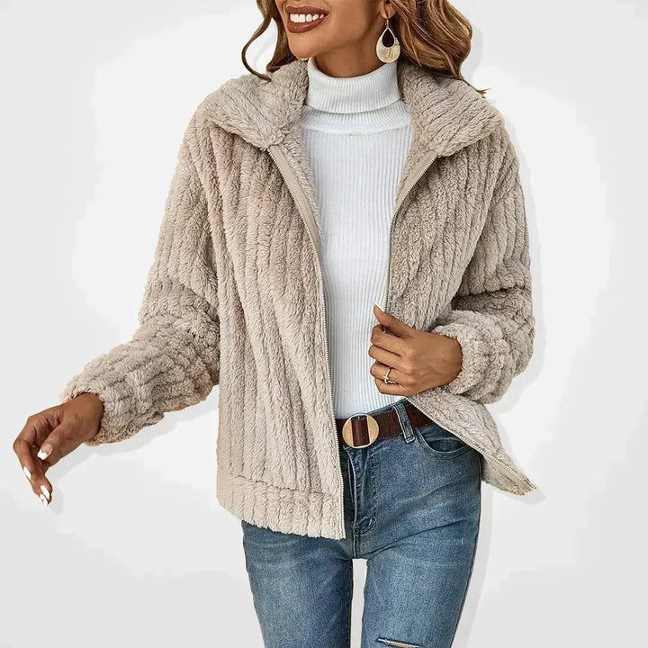 Kvinna som bär beige jacka i mjuk fuskpäls med dragkedja
