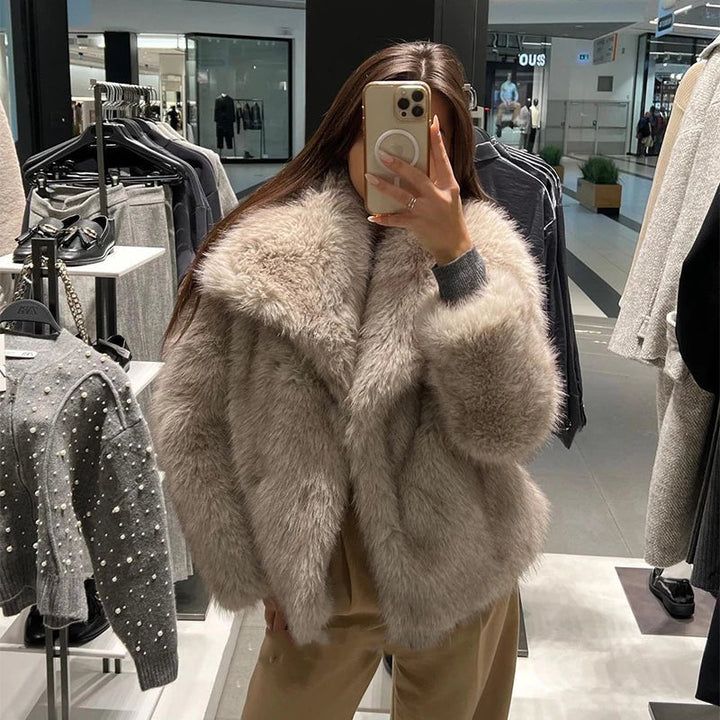 Kvinna i fuskpälsjacka som tar spegelieffektiv bild i butiksmiljö