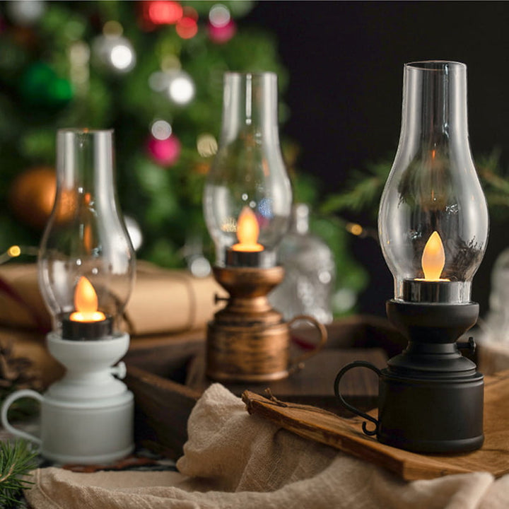 Vintage LED-kerosinlampor i brons, svart och vit uppställda tillsammans