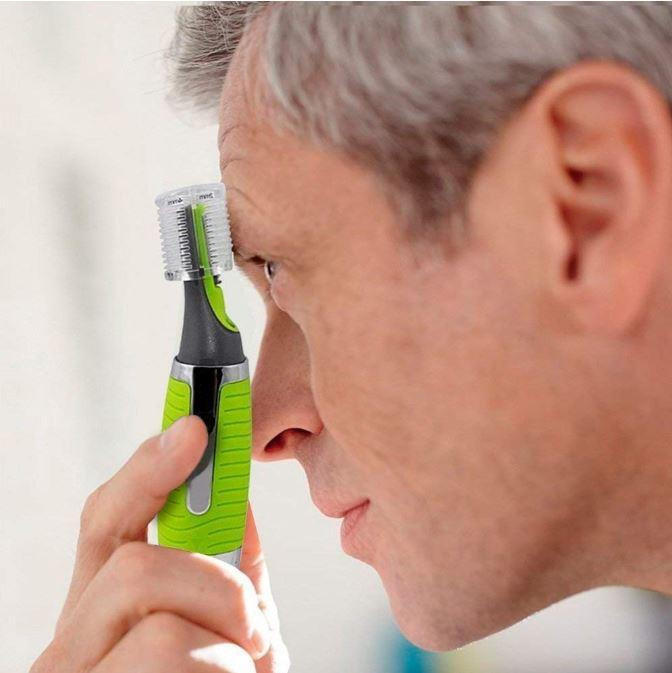 Man som använder mikrotrimmer för att snygga till ögonbrynen