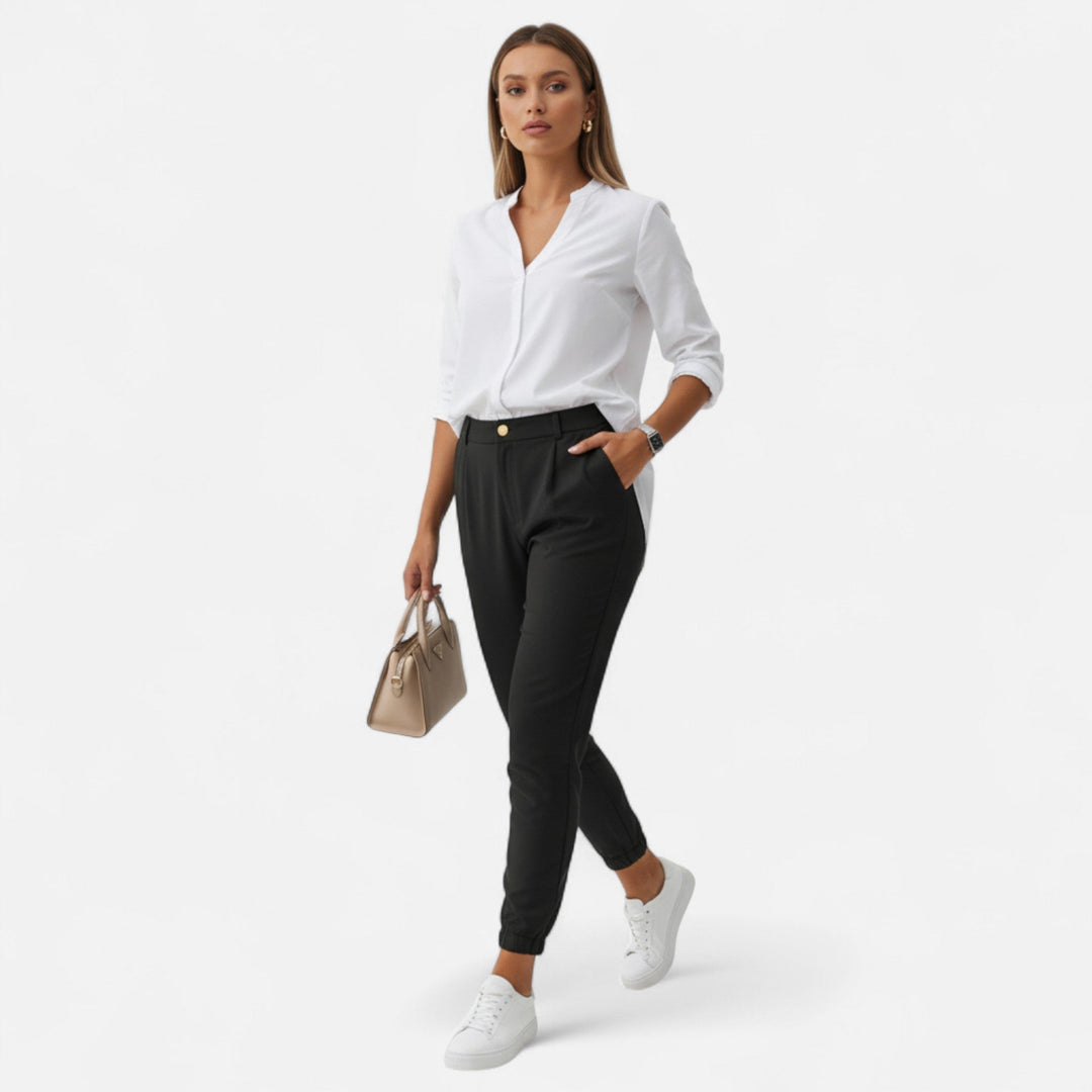 Modell i svarta slim-fit byxor framifrån mot vit bakgrund