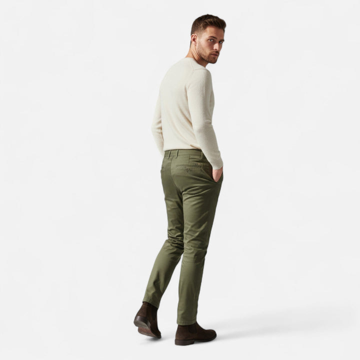 Bakifrån av man i gröna chinos och stövlar för en komplett stil
