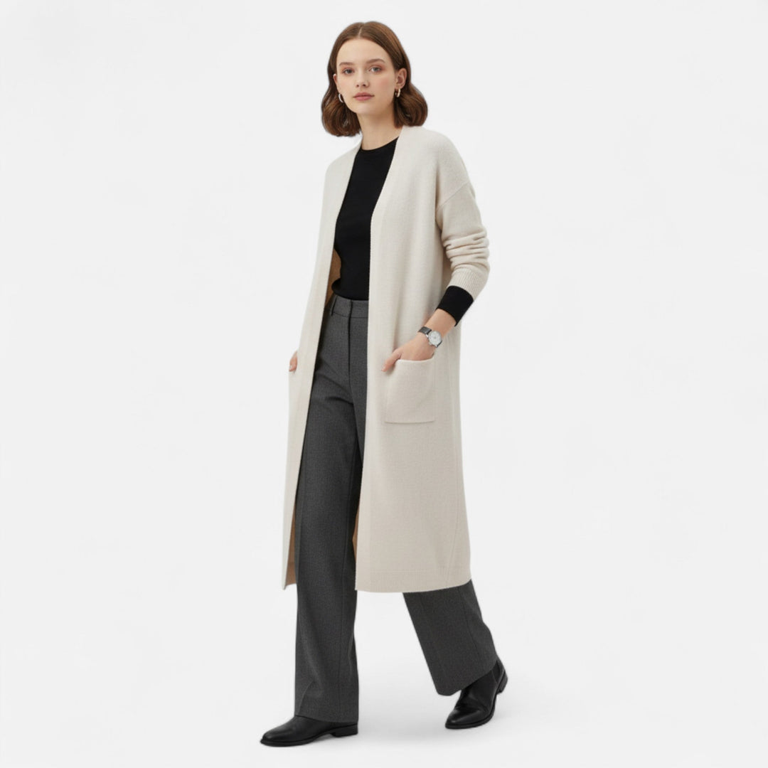 Modell som bär lång beige damcardigan framifrån med svarta byxor